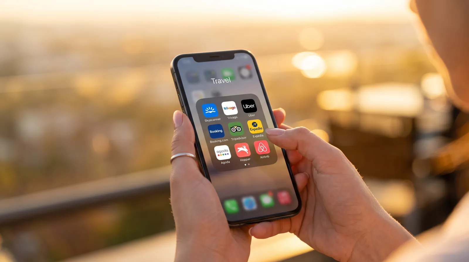 A traveller browsing travel apps on a phone at sunset
